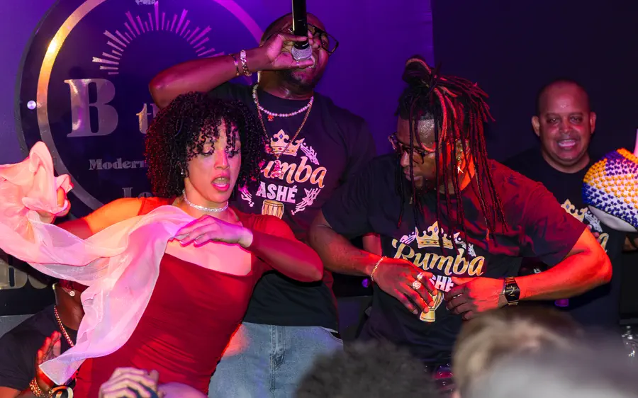 A dancer on the floor with the live band behind her at a CLOO salsa night.